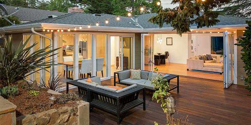 Living room with large glass sliding doors opening onto an outdooring entertaining deck